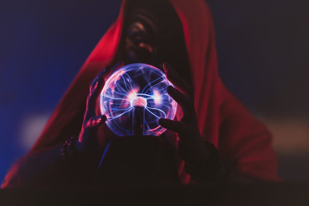 Dark wizard's hands are controlling a magic globe, showing illuminating effects.