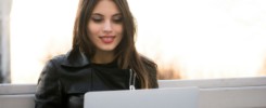 Close portrait of gorgeous dark-hair woman student using laptop computer at campus, charming female