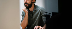 Concentrated young business man employee worker analyzing online sales statistics data on computer