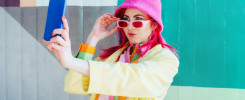 Emotional pink hair woman taking selfie photo on graffiti background.