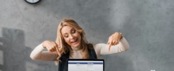 KYIV, UKRAINE - AUGUST 16, 2019: smiling businesswoman pointing with fingers at laptop facebook