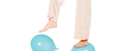 partial view of girl levitating in air and standing on blue ballons