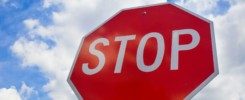 Red stop sign on the street, roadside traffic for stopping.