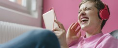 Screaming woman with cell phone and headphones listening to music