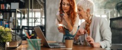 Two female marketing experts discussing strategy and ideas at office.