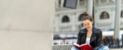 Woman reading book on bench