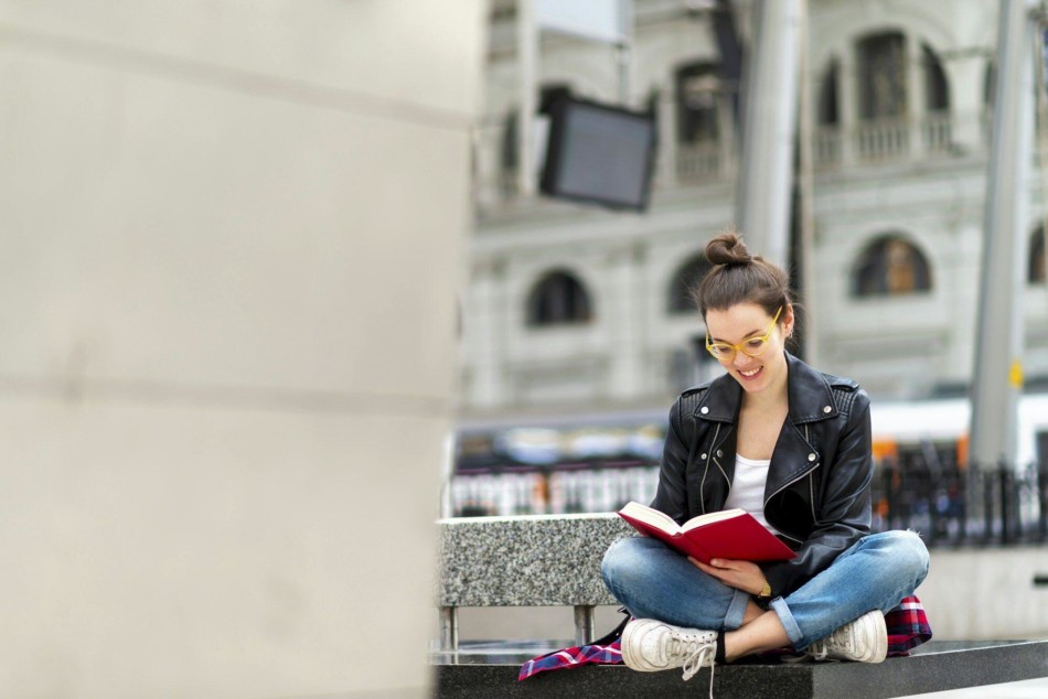 Woman reading book on bench