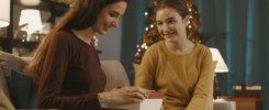 Woman receiving a Christmas gift from her sister