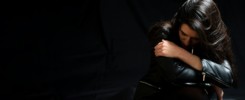 Young woman in a black leather jacket, sad and lonely in a dark room. Depression and grief