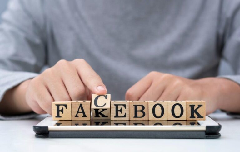Facebook értékesítés: legújabb trendek Hand flipping wooden woording for change "fakebook" to "facebook" on tablet