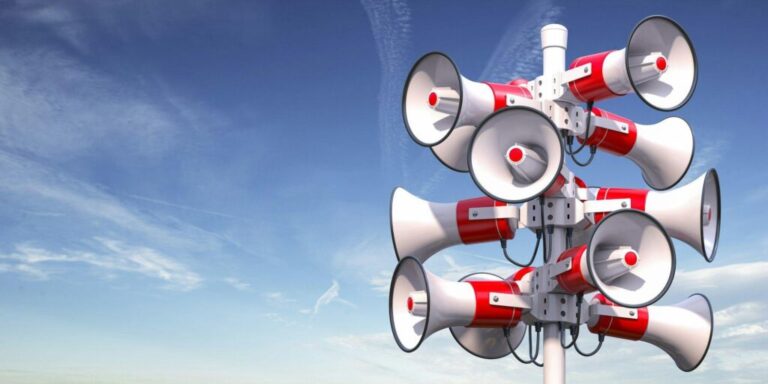 Reklám és promóció: eltérések és szerepük Megaphones and ublic speakers on a pole. Announcement, warning, promotion concept.