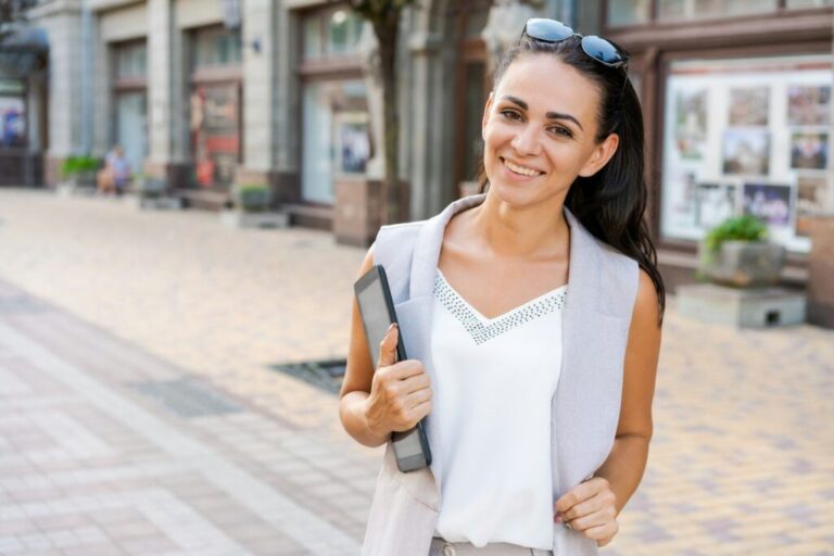 Miért akarsz marketinges lenni? Confident young woman laughing and carrying notepad in hand while standing