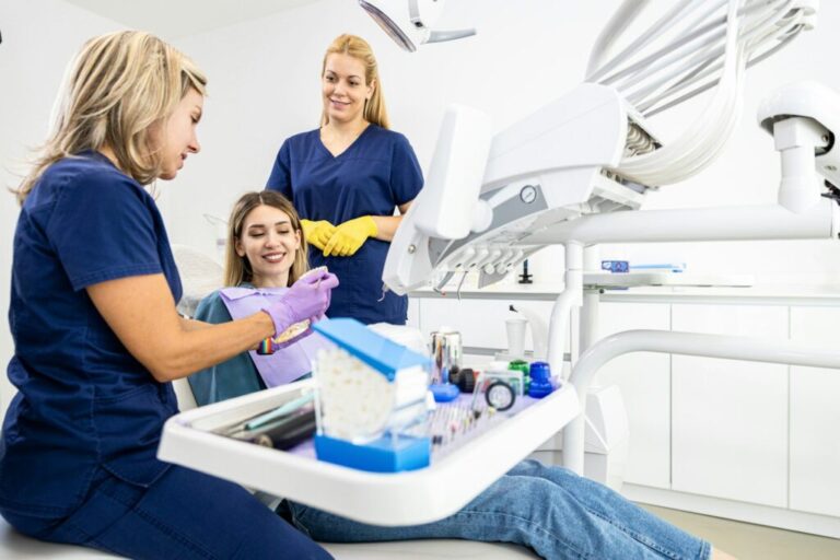 Fogászati rendelő modern marketingje Female dentist with assistant working in dental clinic examining patient teeth.