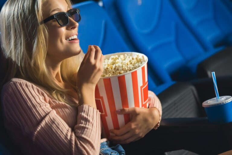A tudatalatti befolyásolás ereje side view of smiling woman in 3d glasses with popcorn watching film alone in cinema