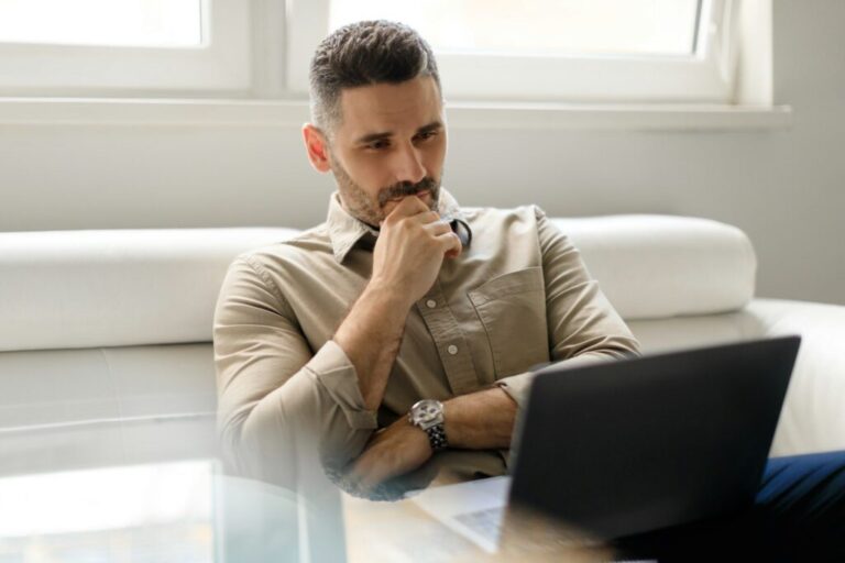 Önreflexió a marketingben Focused thoughtful businessman using laptop and thinking of project, making decision, looking at