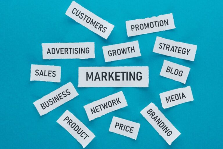 A marketing tanácsadás előnyei top view of components of marketing on pieces of paper on blue