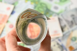 100 dollars like a funnel in hand against the background of the European currency.