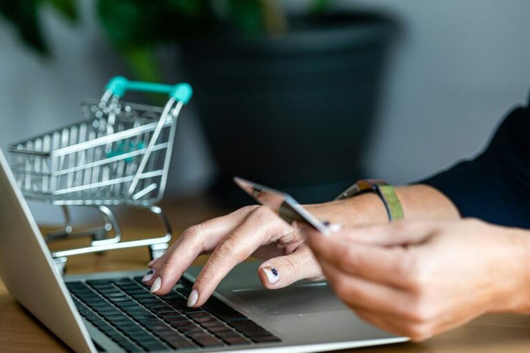 Webáruház indítása: a bukás okai close-up of a woman hands buying online with a credit card and a laptop, e-commerce concept