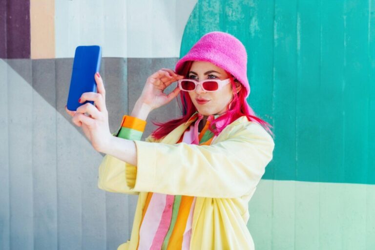 Az érzelmek szerepe a reklámhatásban Emotional pink hair woman taking selfie photo on graffiti background.
