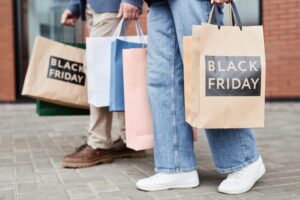 Of couple holding Black friday shopping bags walking together outdoors