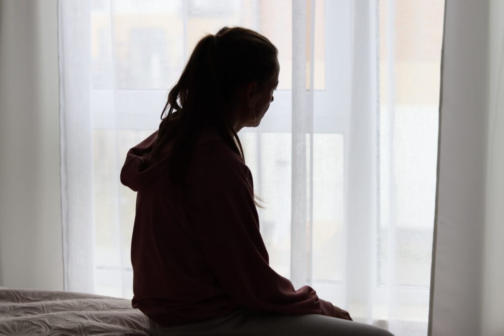 A young woman indorrs at home feeling stressed, mental healt.
