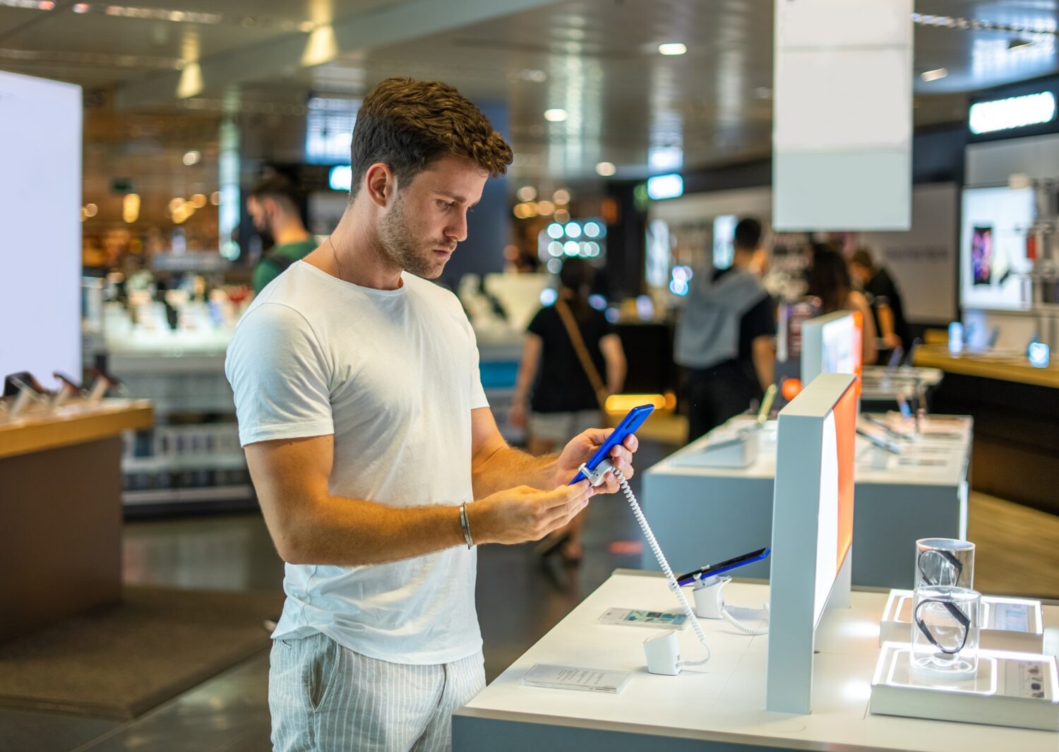 A fogyasztói szocializáció Buyer with smartphone in electronics shop