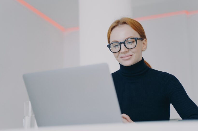 Confident young woman is boss at workplace in office. Manager is browsing the information.