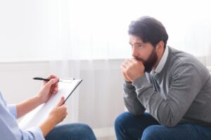 Depressed man getting psychological treatment at clinic