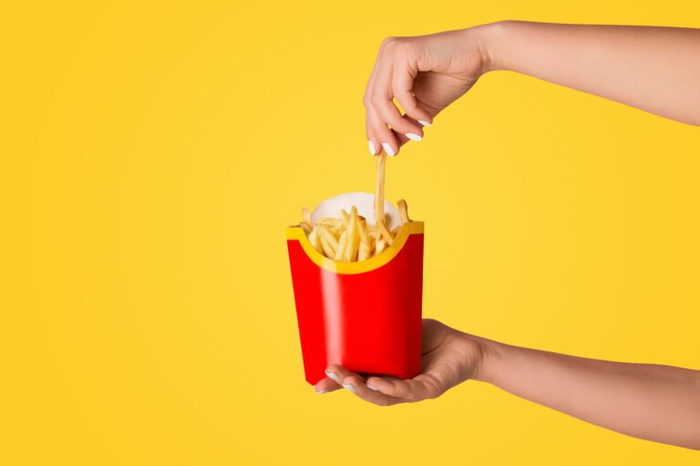 Mit tanulhatunk a Mcdonald’s marketingeseitől? KHARKIV, UKRAINE - APRIL 4, 2020: Young girl holding pack of french fries from McDonald's on pink