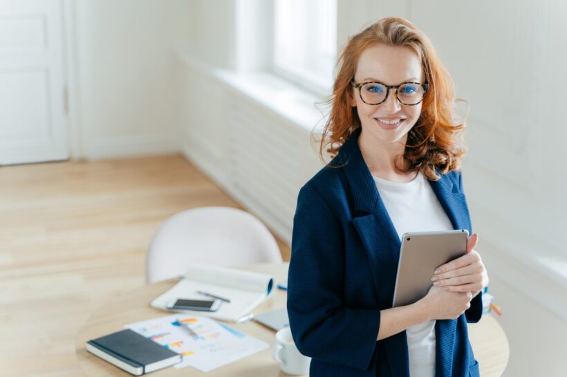 A digitális transzformáció Prosperous female leader of working team holds digital tablet device, develops business ideas