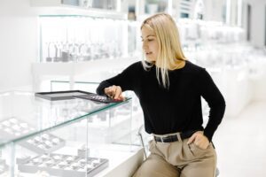 Saleswoman calculating price using calculator in jewelry shop