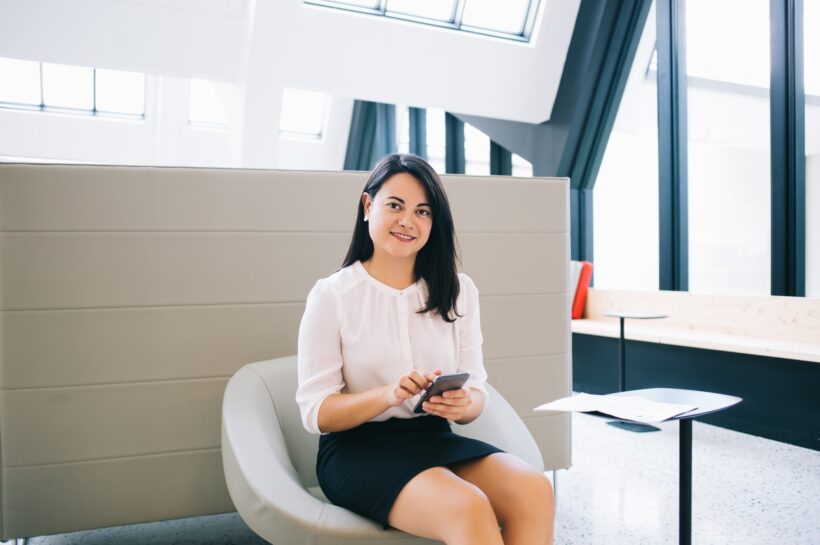 smiling sucessful businesswoman using smartphone for chatting and online communication
