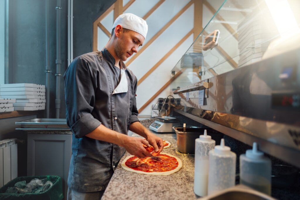 The chef prepares pizza. Catering kitchen work.