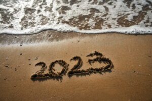 Ezt tanultuk a 2023-as évből üzleti és marketing szempontból 2023 written over the sand of the beach.