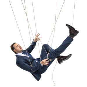 businessman trying to break free while hanging on manipulating ropes isolated on white