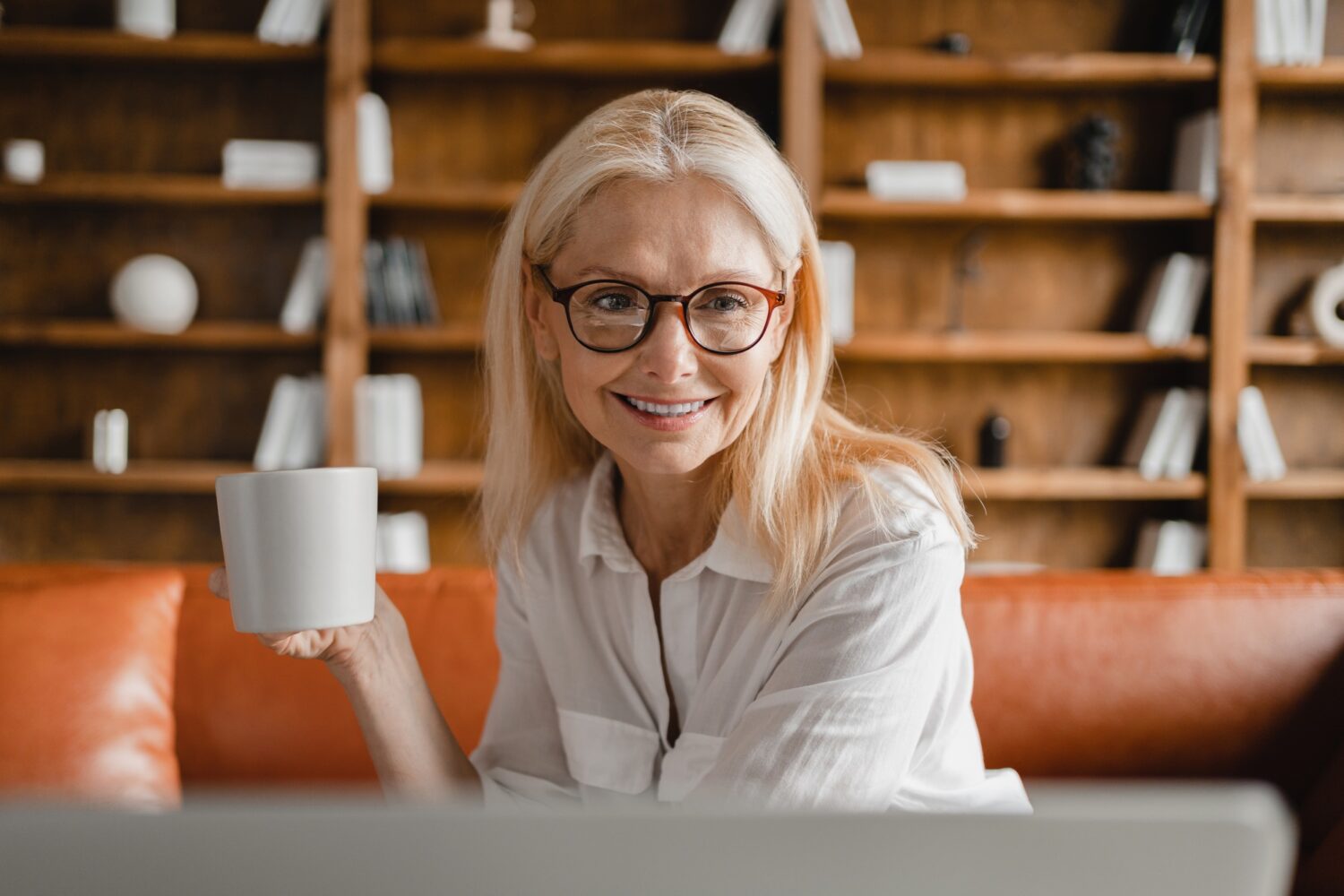 Értékközpontú (neo-karizmatikus) leadership-elméletek Businesswoman leader teacher tutor working on laptop on distance online, drinking,watching webinars
