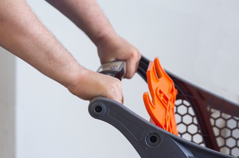 Close-up of a buyer's hand on a cart in a supermarket