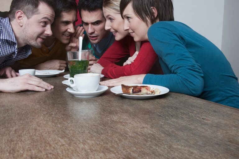 Friends whispering at party.