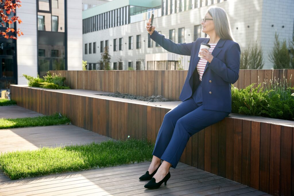 Successful business-lady taking a photo of herself in fancy suit