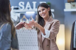 Woman seller and buyer in clothes store