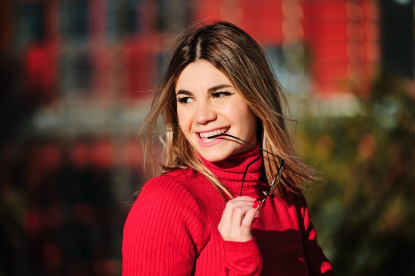 Woman smiling outdoors on the street.