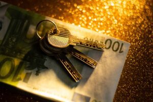 keys and money banknotes on golden background