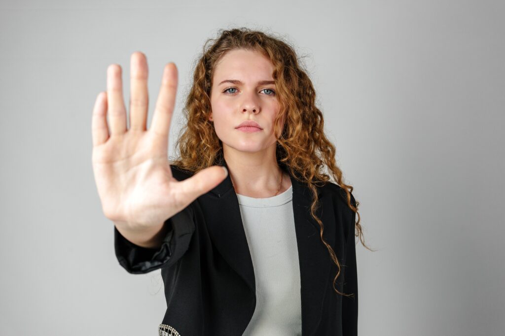 Woman With Curly Hair Holding Hand Up
