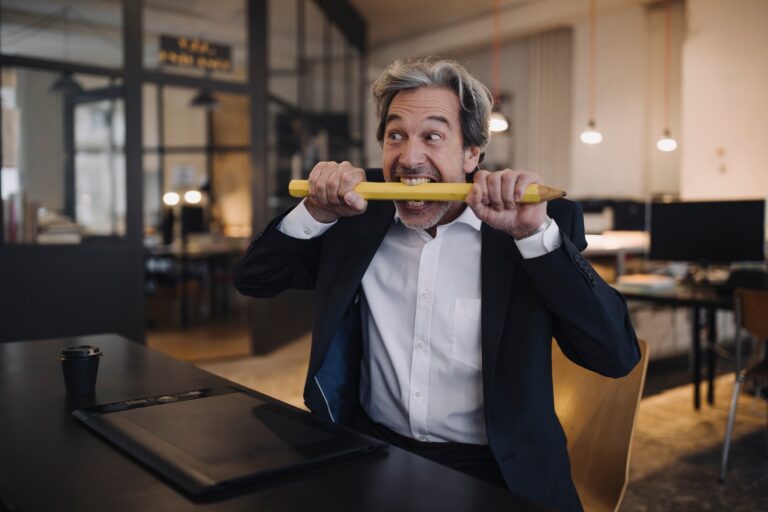 Gyakran alkalmazott etikátlan és káros marketingtechnikák Angry senior businessman with giant pencil at desk in office