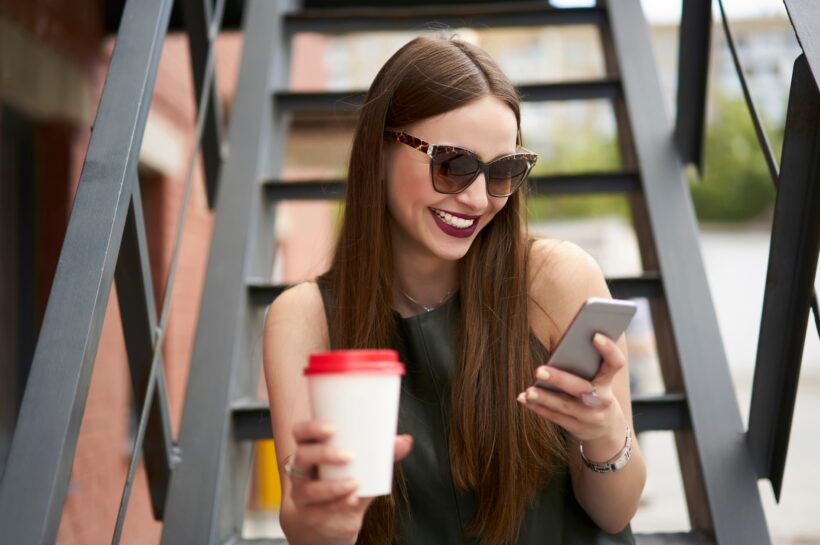 Amikor nevetésből vásárlás lesz Happy Caucasian tourist with coffee to go reading funny publication in networks