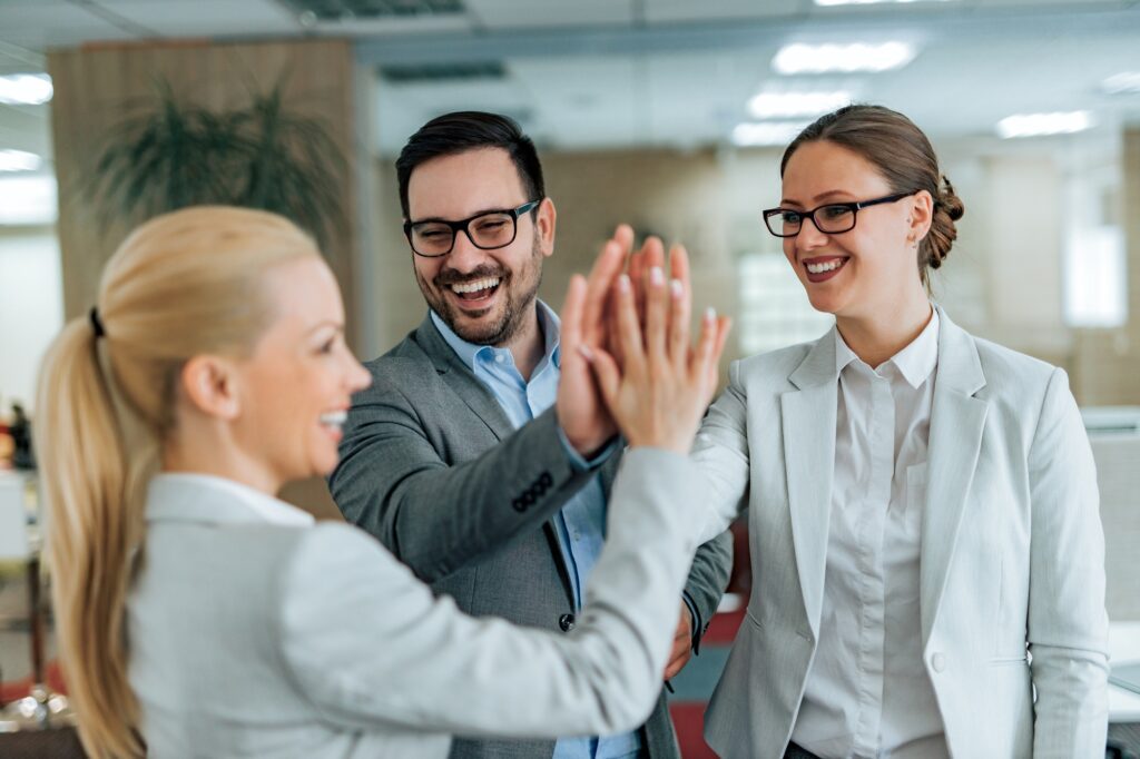 Motivated workers celebrating teamwork achievement. Business people high five, portrait.
