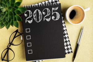New year resolutions 2025 on desk. 2025 resolutions list with notebook, coffee cup on table