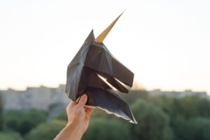 Silhouette of head black paper 3d unicorn on sunset background