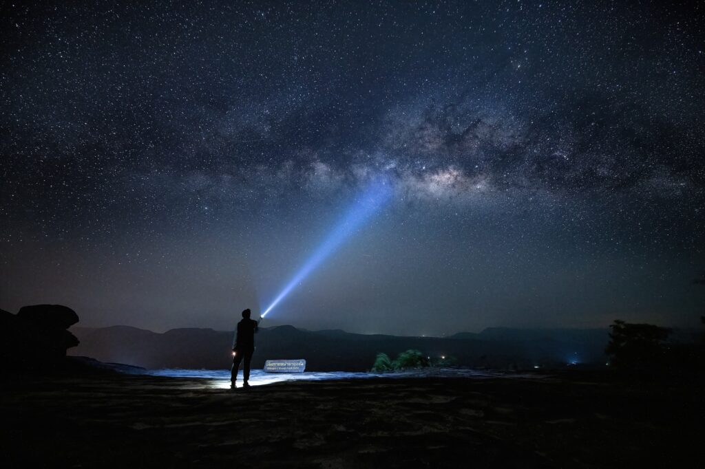 Silhouette traveler hold lighting point to sky with night starry sky milky way is travel and nature