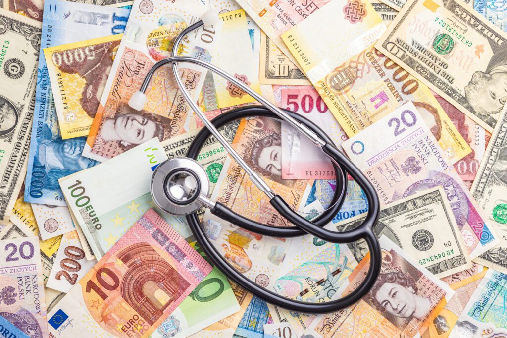 Stethoscope on various banknotes background. Top view.